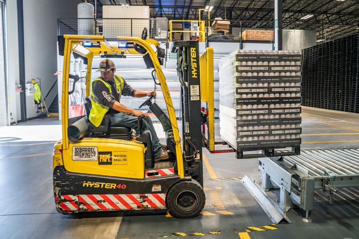 Forklift loading palletised cargo at a warehouse dock