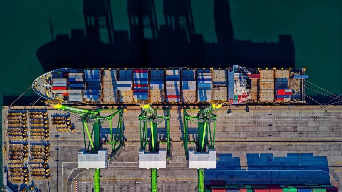 Gantry cranes loading containers onto a berthed cargo vessel from above